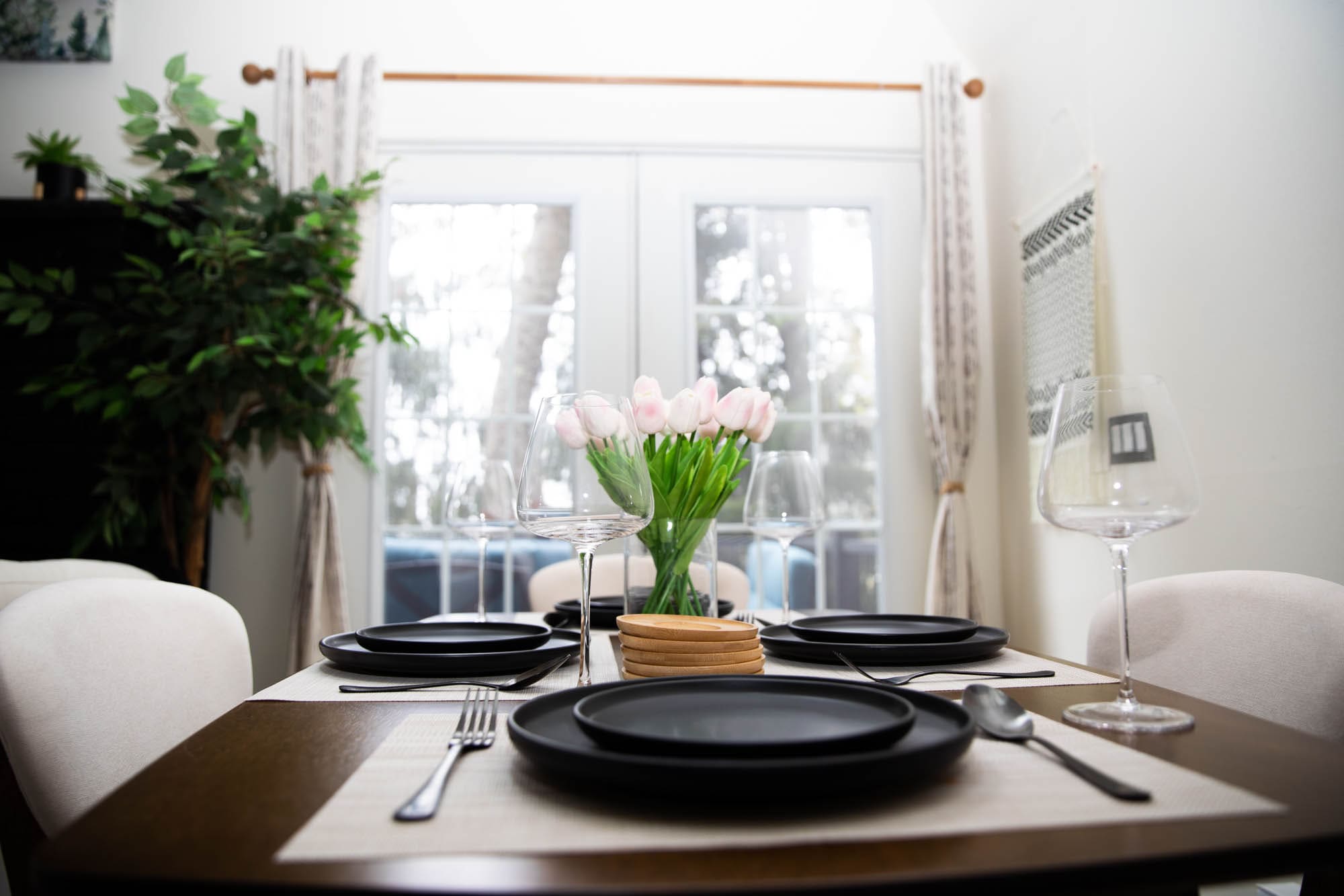 Dining table set for four beside the French doors of the A-frame cabin in the Poconos