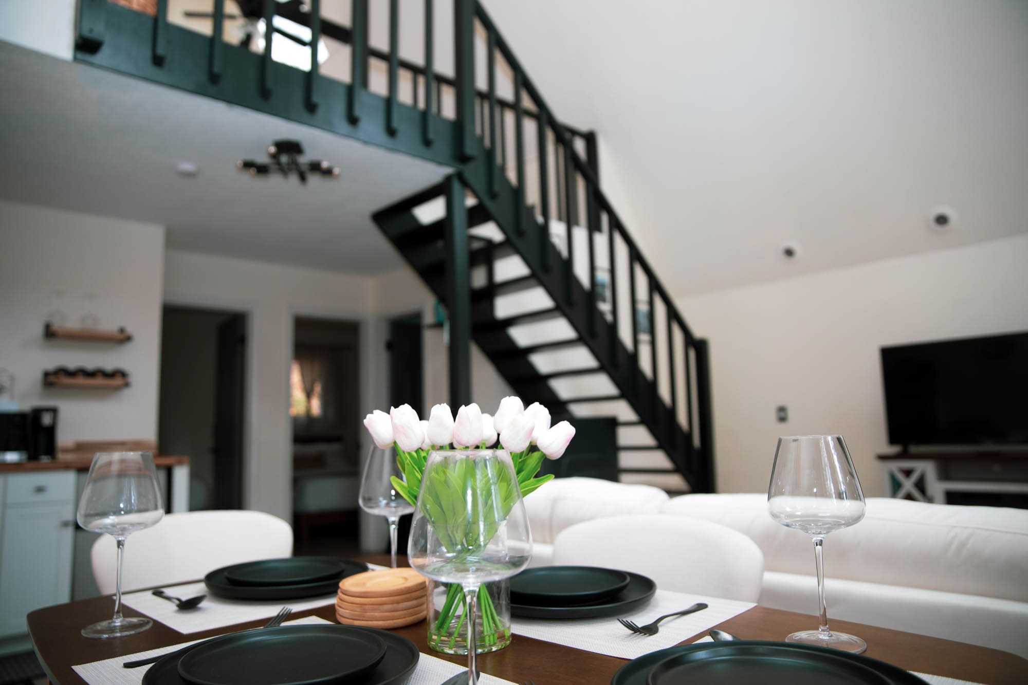 Open living and dining area inside Bella Casa Cabin with the staircase leading up to the A-Frame loft